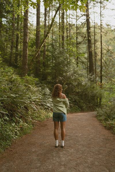 girl sitting with dog in washington nature park