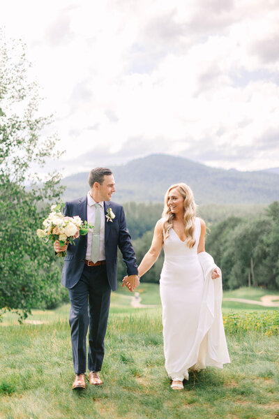 Bride and Groom standing forehead to forehead  at dusk with the water behind them