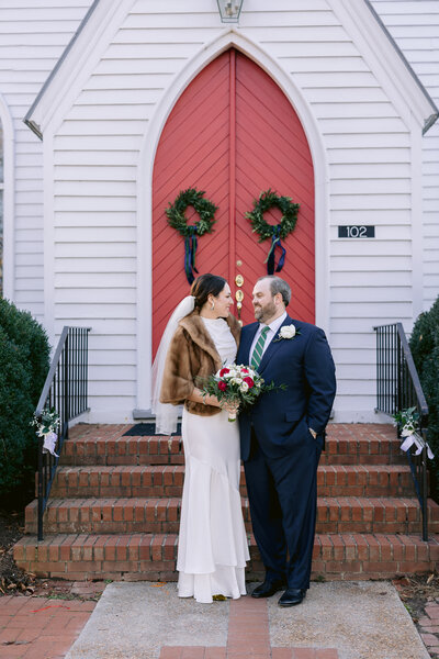 couple standing in front of quaint small church