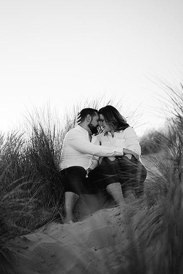 Photograph of engaged couple sharing a special moment at Camber Sands beach, East Sussex, UK