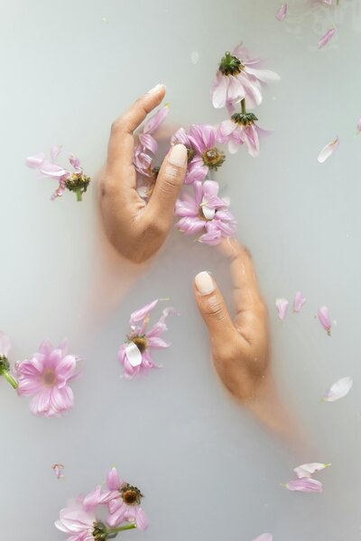 Flower petals floating in woman's bath