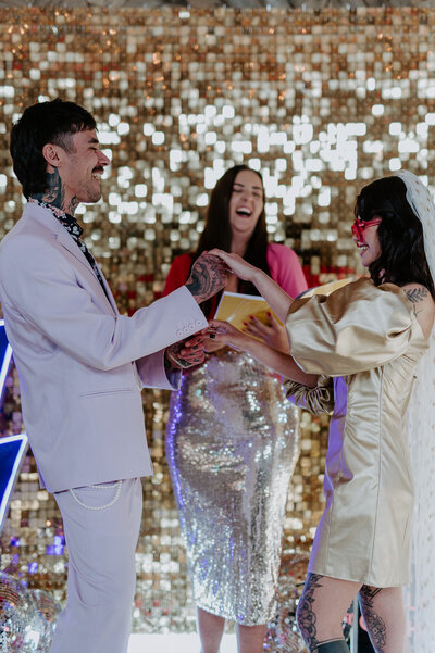 A celebrant performs a ceremony at a disco themed wedding at The Canary Shed in Essex. 