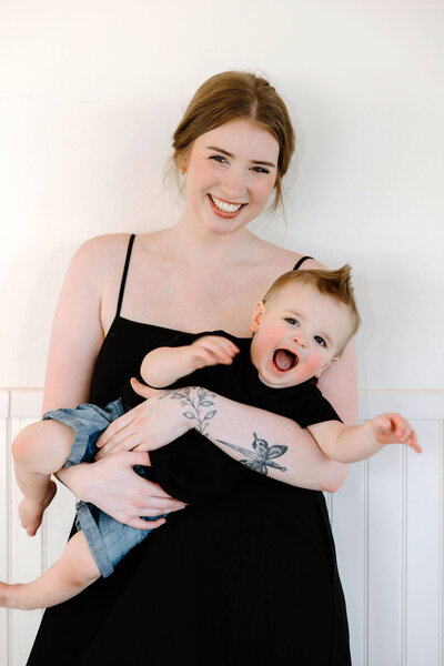 mother holding one year old son and laughing during milestone 1 year family photos Longview, TX