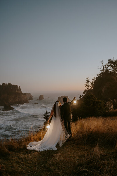 Bride and groom at secret beach blue hour lantern photos