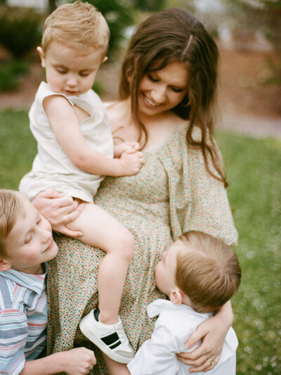 mother holds children close during maternity session at huntsville botanical garden with fauna & film