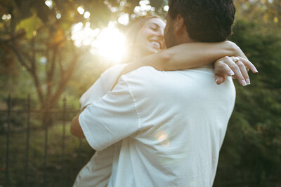 Couple spins together in golden hour light during their engagement session in downtown Nashville, TN.