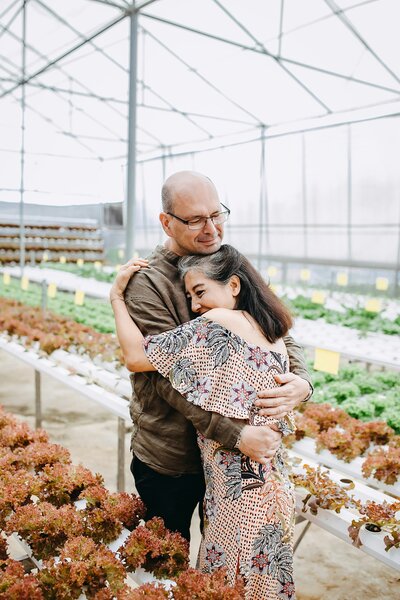 Hayden Dover embracing his wife in a greenhouse, representing nurturing relationships and personal growth