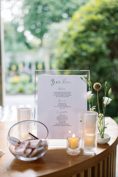 White bar menu with green watercolor calligraphy in acrylic  frame