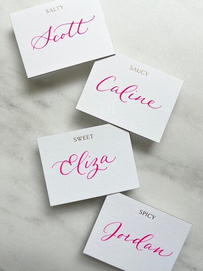 Place cards with bright pink calligraphy