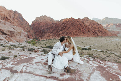 couple sitting together on red rocks in Nevada