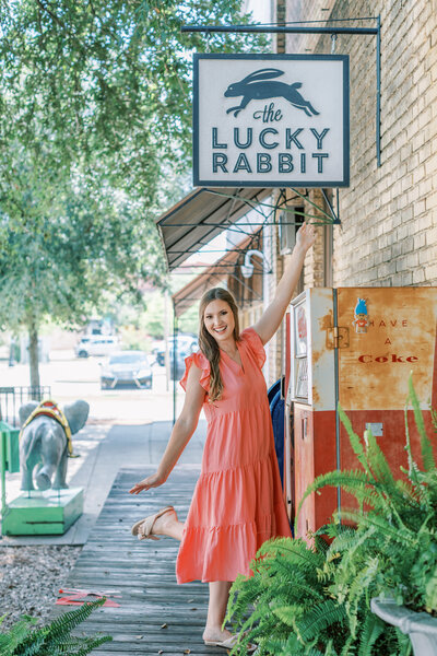 A Mississippi wedding photographer stands under The Lucky Rabbit sign.