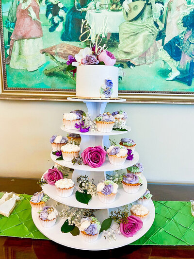 Purple floral cake and cupcake display for a bridal shower