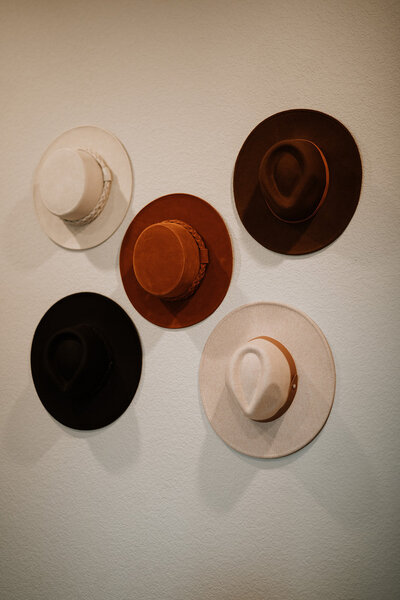 5 hats hanging on wall