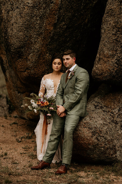 groom and bride stand in Rocky Mountain crevice during wedding portraits.