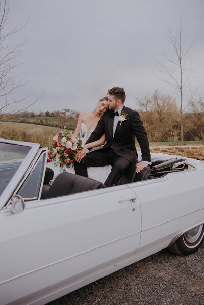 bride and groom sitting in antique car 