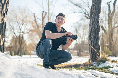 A freelance photographer crouching for an action shot.