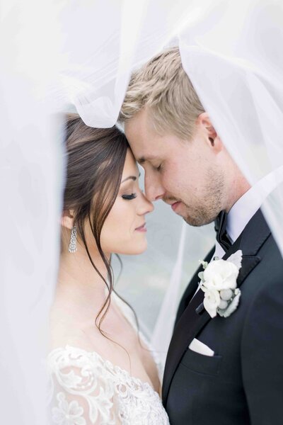 couple embracing for a kiss under veil