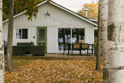 White cottage in the woods during fall time