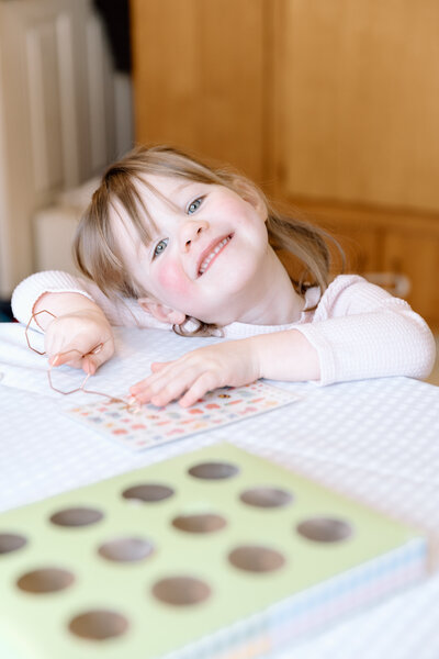 Child smiling while decorating Easter eggs.