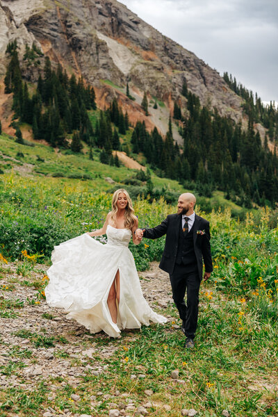 Denver Wedding Photographer captures newly engaged couple holding hands during outdoor photos after mountain wedding