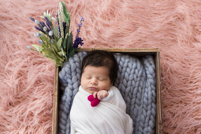 Posed newborn baby girl holding a heart during an in-home Philadelphia Newborn Session