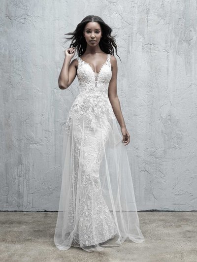 A sheer layer of tulle creates the illusion of an A-line skirt overlay against a sheath gown.