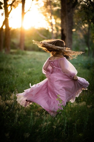 image of girl spinning around in a pink dress