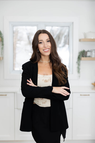 Professional headshot of a realtor, standing confidently in a modern kitchen. The setting is a stylish Airbnb booked for his branding session, featuring bright, natural lighting and contemporary design elements.