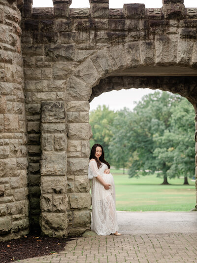 pregnant mom in white lace dressholding belly for portrait cleveland maternity photographer
