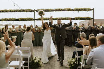A recessional photo of a bride and groom during their gorgeous rooftop wedding in Holland, Michigan. 