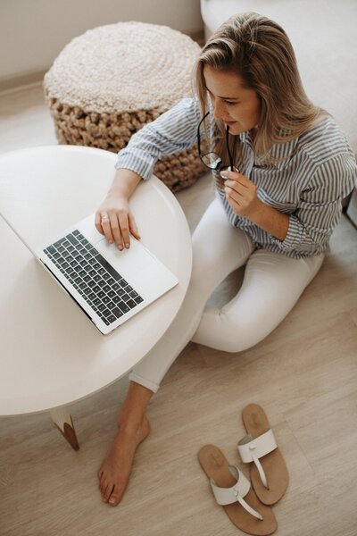 Blonde woman sitting at laptop looking at site