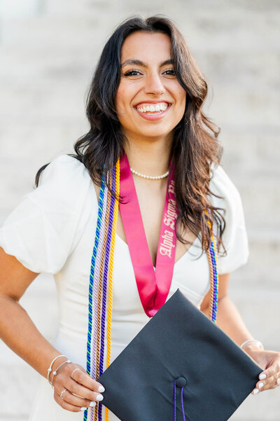 Cute grad holding her cap at Assumption University taken by best college grad photographer in Worcester, MA