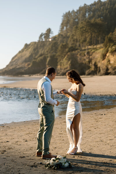 Couple reading vows on a beach.