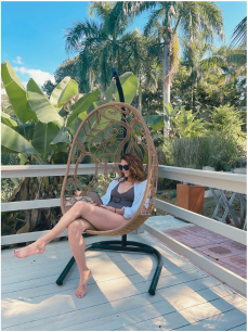 Woman reading in chair with tropical background  - tales of adventure