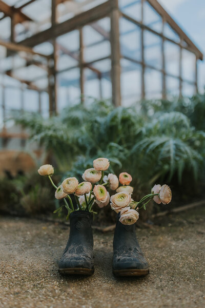 Flowers sticking out of rubber work boots in greenhouse