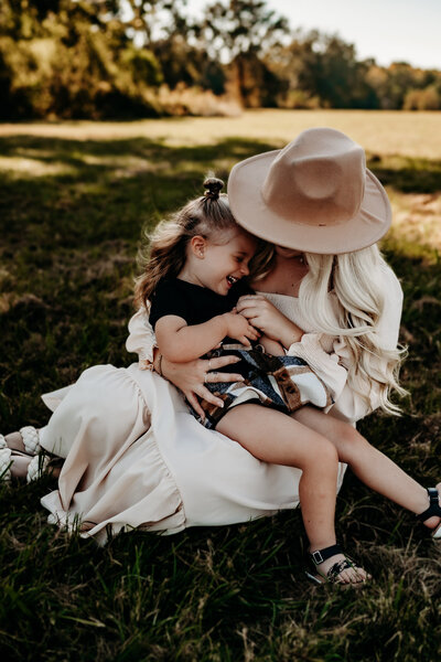 A happy family poses together in a lush park, showcasing their love and connection in a Louisiana lifestyle portrait.