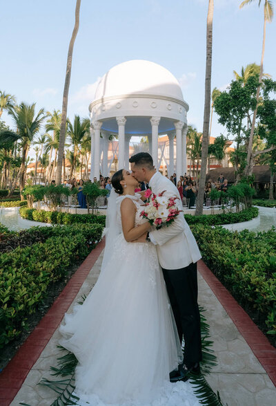 The bride and the groom are posing at the beach