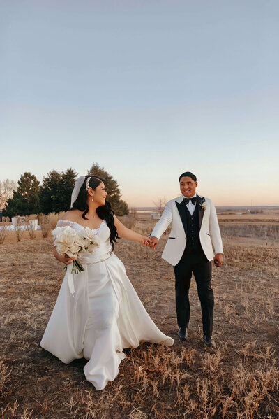 bride and groom looking at each other intimately on a field