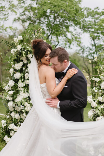 groom romantically kisses bride on the shoulder