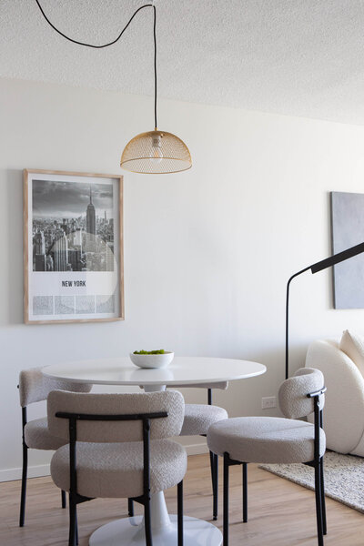 modern condo dining room staging with white tulip table and boucle dining chairs