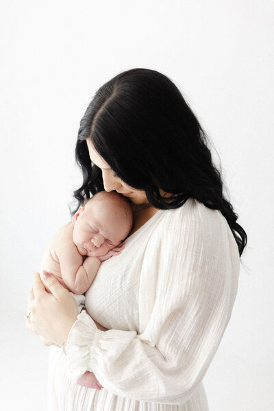A baby girl sleeping on her tummy on a soft pink blanket during her newborn photography session. 