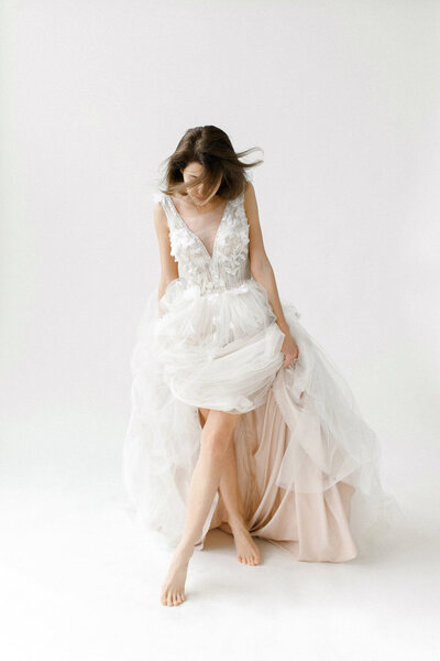 Bride wearing a white tulle wedding gown with floral lace bodice, fitted by professional bridal seamstress.