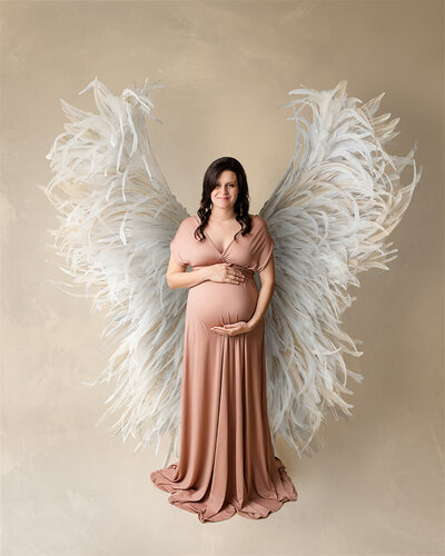 Mother with hand on her belly and angel wing