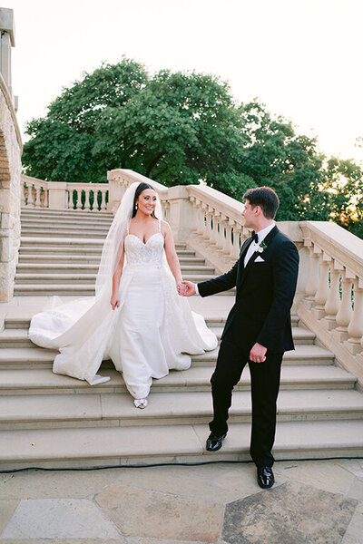 Bride walking down the steps with groom holding her hand at luxury Dallas wedding