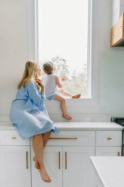 photo of mom holding baby with dog taken through glass door
