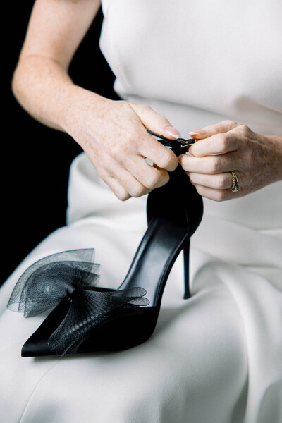 In this intimate moment captured by Tiffany Longeway, a European bride exudes grace as she delicately puts on her shoes, embodying the elegance and anticipation of the wedding day.