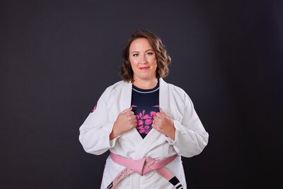 Owner of Evolve Therapy & Consulting posing in her martial arts uniform