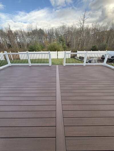 A Composite brown deck with white and black PVC railings 