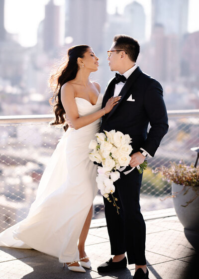 Brice and groom with white bouquet on the rooftop of Public Hotel in NYC