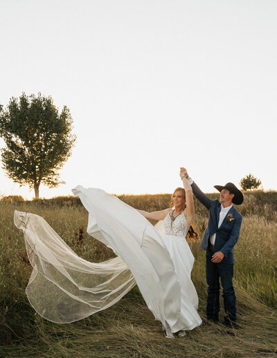 a groom twirling the bride in her wedding dress
